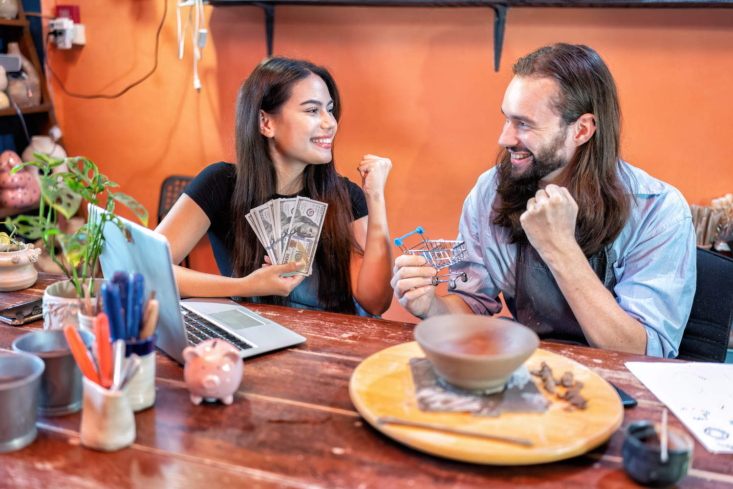 couple in an Online Fortune Telling session - woman holds dollar bills man holds a tiny shopping cart