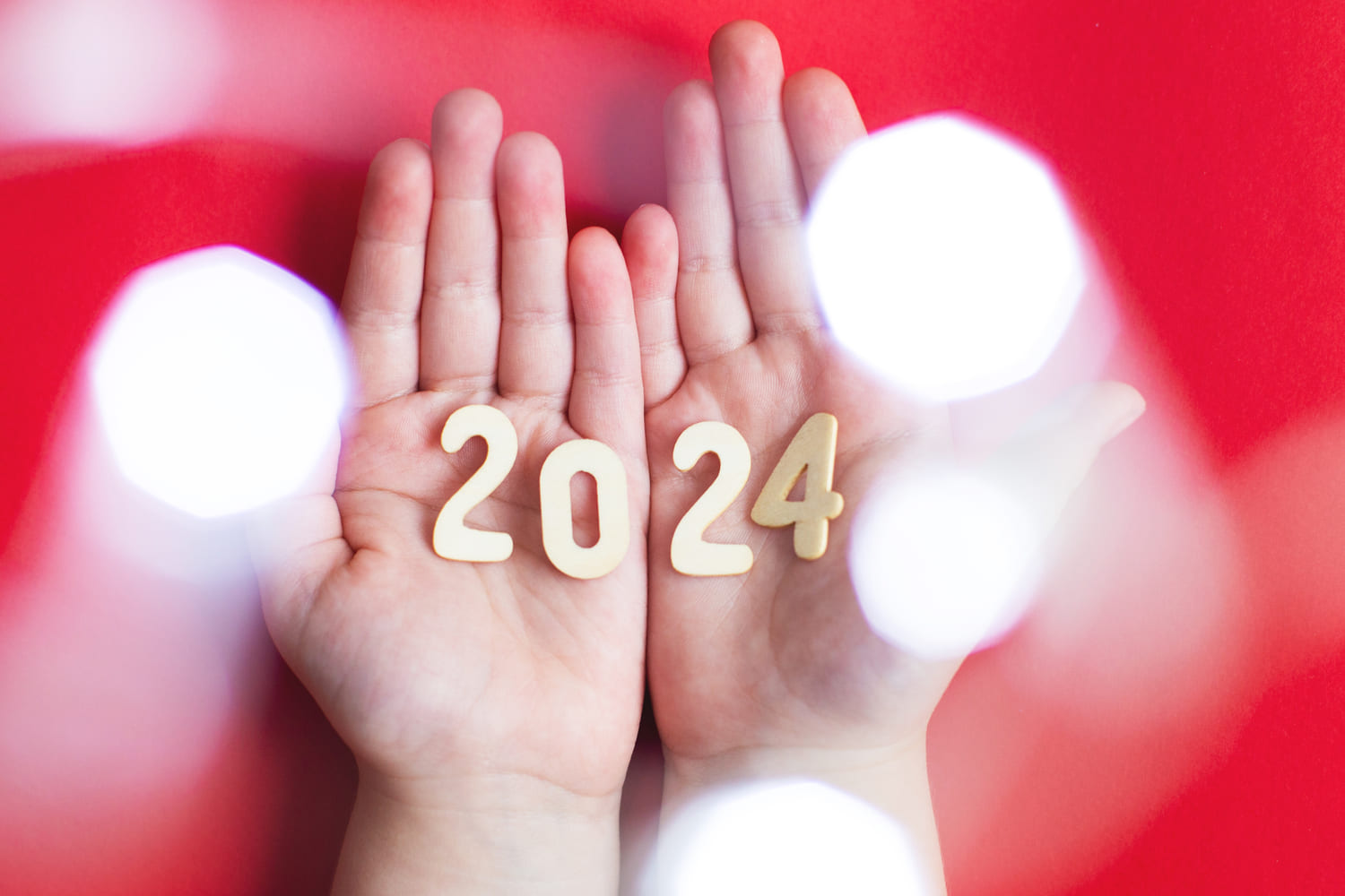 Psychic Predictions - hand palms holding wooden number 2024