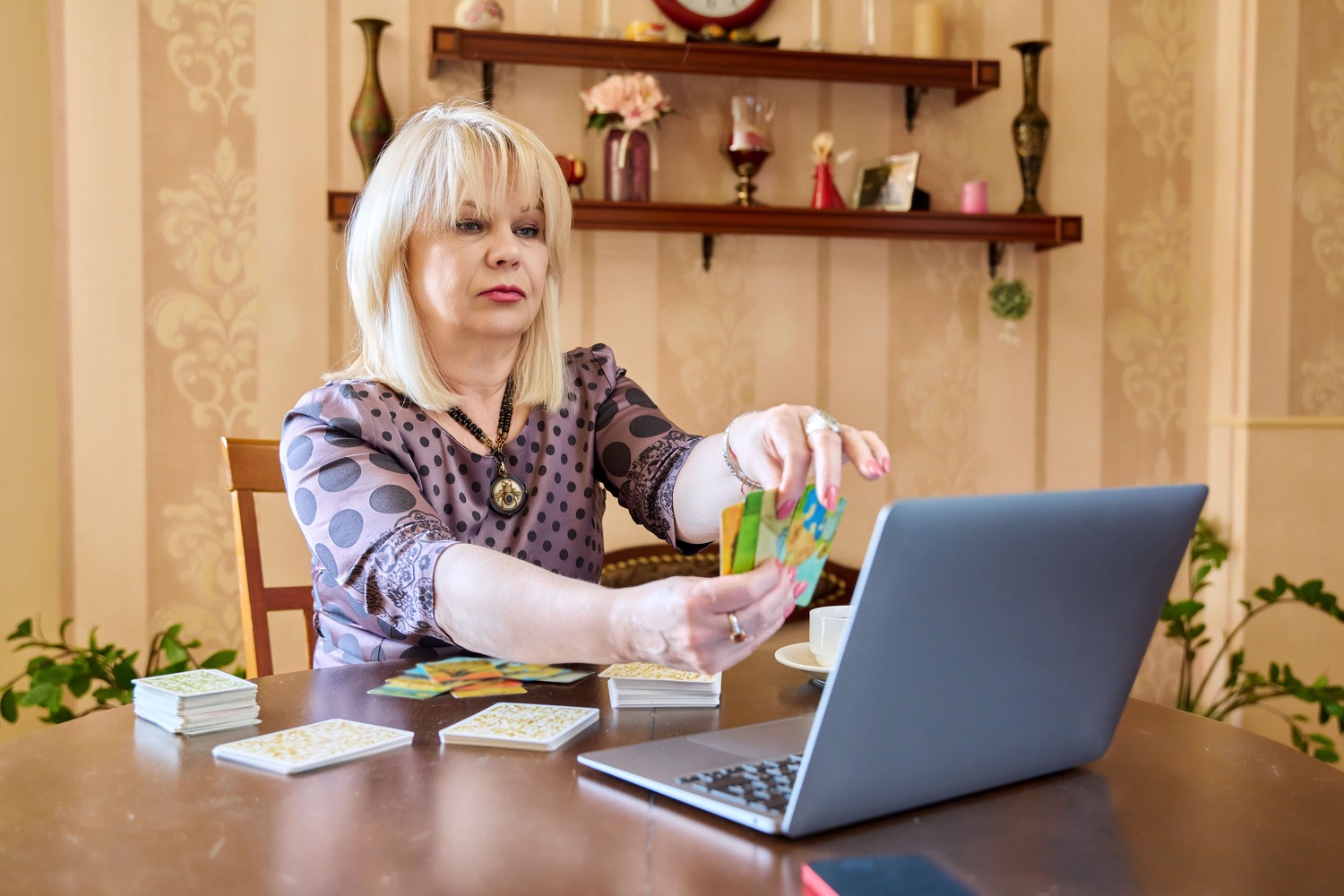 Online Psychic Reading - Woman holding cards in front of a computer